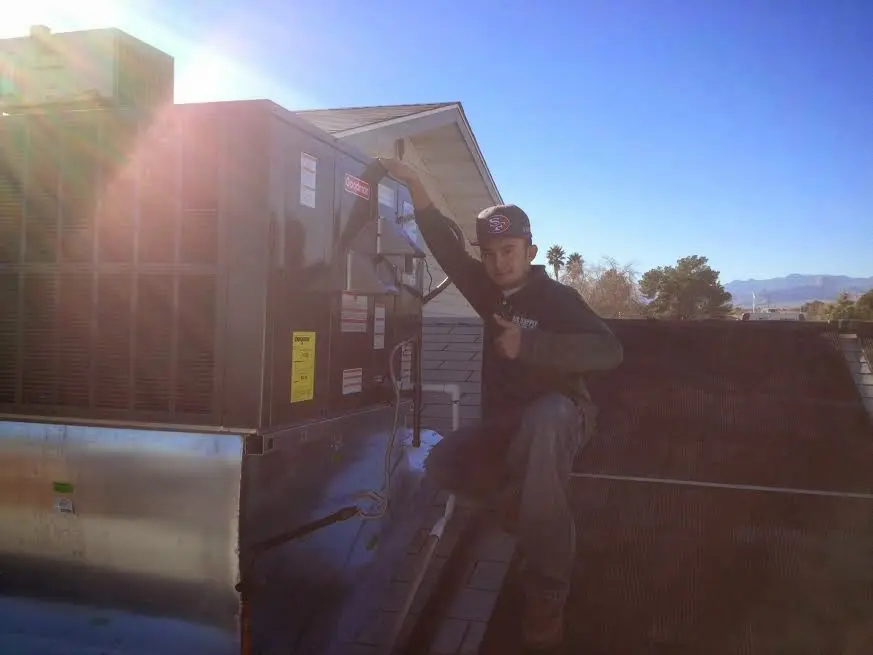 HVAC technician performing Heat Pump Repair on a rooftop unit in Eastampton